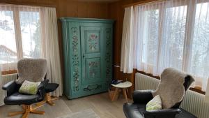 un soggiorno con due sedie e una porta verde di Chalet Acheregg a Wengen