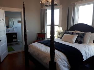 a bedroom with a four poster bed and a window at Hillside Landing B&B in Digby