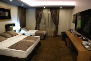 Giường trong phòng chung tại Erbil Quartz Hotel