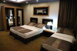 Giường trong phòng chung tại Erbil Quartz Hotel