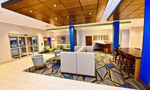 una hall di un hotel con tavoli e sedie di Holiday Inn Express & Suites - Perryville I-55, an IHG Hotel a Perryville