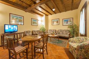 a living room with a table and chairs and a television at Hotel Plestina Ristorante Pizzeria in Foligno