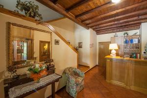 a living room with a mirror and a chair at Hotel Plestina Ristorante Pizzeria in Foligno