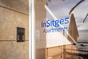 a glass door with the words in sites apartments on it at InSitges Sant Sebastia's Beach in Sitges