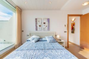 a bedroom with a bed with a blue comforter at InSitges Sant Sebastia's Beach in Sitges