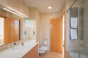 a bathroom with a sink and a toilet and a mirror at InSitges Sant Sebastia's Beach in Sitges