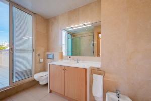 a bathroom with a sink and a toilet and a mirror at InSitges Sant Sebastia's Beach in Sitges