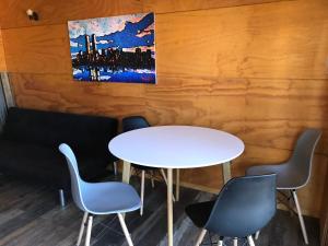 une table et des chaises dans une pièce ornée d'un tableau mural dans l'établissement Tongoy Beach Tinyhouse, à Tongoy