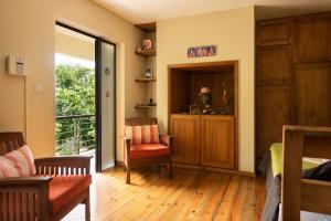 a living room with a couch and a chair at Happy Days Guest House in Le Morne