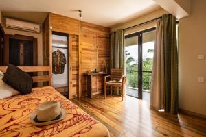 a bedroom with a bed with a hat on it at Happy Days Guest House in Le Morne