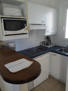 a kitchen with white cabinets and a black counter top at Lagrange Vacances Le Hameau De Peemor Pen in Crozon