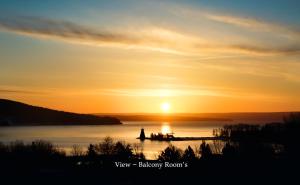 a group of people on a dock at sunset at Telegraph House Motel in Baddeck