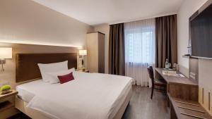 Giường trong phòng chung tại Hotel Newton Heilbronn