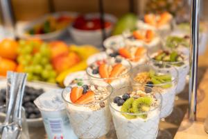 un buffet de fruta en tazas de plástico con yogur y fruta en Flöckner B&B, en Salzburgo