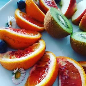 un plato de fruta con naranjas y kiwis en B&B 1 uit de 100, en Gante