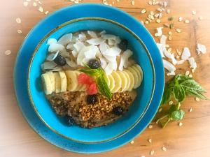 un cuenco azul de comida con frutas y verduras en una mesa en Mantra Gili, en Gili Trawangan