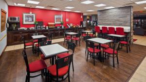 un restaurant avec des murs rouges, des tables et des chaises rouges dans l'établissement Chicago Southland Hotel, à Oak Forest