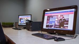 un bureau avec un moniteur d'ordinateur, un clavier et une souris dans l'établissement Chicago Southland Hotel, à Oak Forest