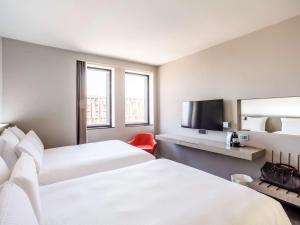 Cette chambre comprend 2 lits et une télévision à écran plat. dans l'établissement Pullman Toulouse Centre Ramblas, à Toulouse