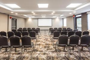 een conferentieruimte met stoelen en een projectiescherm bij Holiday Inn Roanoke Airport - Conference CTR, an IHG Hotel in Roanoke