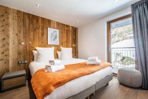 una camera da letto con un grande letto con asciugamani di Le Globe Argentière Chamonix - by EMERALD STAY a Chamonix-Mont-Blanc