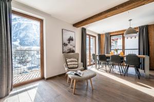 un soggiorno con tavolo, sedie e finestre di Le Globe Argentière Chamonix - by EMERALD STAY a Chamonix-Mont-Blanc