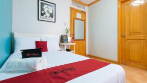 um quarto com uma grande cama branca com almofadas vermelhas em RedDoorz @ Arimbay Legazpi City em Legazpi