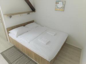 リュブリャナにあるEvi Rooms Ljubljanaの小さなベッド(白いシーツ、箱2つ付)