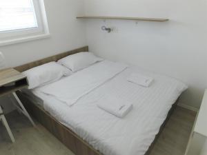 リュブリャナにあるEvi Rooms Ljubljanaのベッド(白いシーツ、白い枕付)