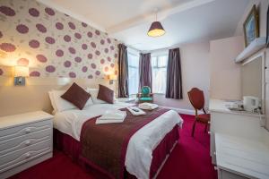 een hotelkamer met een groot bed met rode loper bij Barrowfield Hotel in Newquay