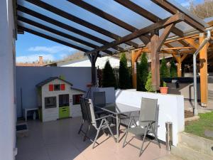 a patio with a table and chairs and a dog house at Panni Vendégház in Egerszalók