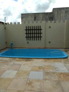 a large blue swimming pool in front of a wall at LINDO SOBRADO COM PISCINA PARA ATÉ 10 HÓSPEDES! in Natal