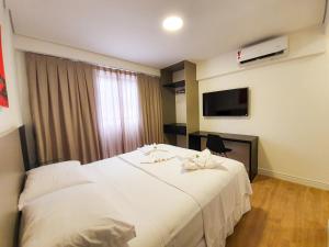 Rúm í herbergi á Easy Suites Natal