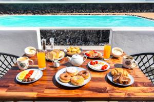 un tavolo con prodotti per la colazione e bevande e una piscina di Abasa Suites a Firà