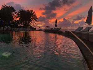 uma piscina com um pôr-do-sol ao fundo em Hodges Bay Resort & Spa em São João