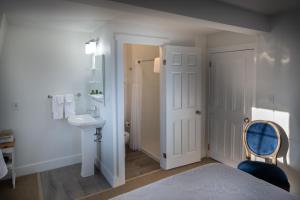 a white bathroom with a sink and a toilet at Telegraph House Motel in Baddeck