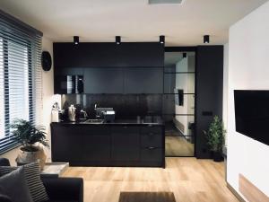 una cocina con armarios negros y una cocina con un asterisco en Jacuzzi Apartments, en Cracovia