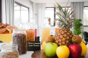 a table with a pineapple and other fruits and nuts at Porto Romano - The Marina Resort in Fiumicino