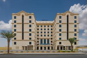 un grande edificio bianco con alberi di fronte di The Manor By JA, Dubai a Dubai