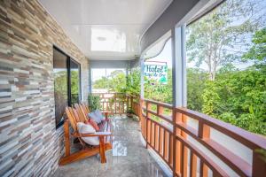 a porch with a rocking chair on a balcony at Hotel Hoja de Oro Corcovado in Puerto Jiménez