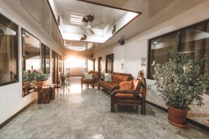 a hallway with chairs and plants in a building at Hotel Hoja de Oro Corcovado in Puerto Jiménez