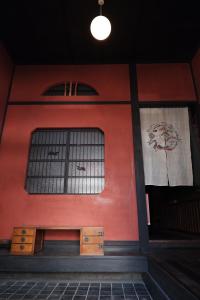 ein Gebäude mit einer roten Wand und einem Fenster in der Unterkunft 一棟貸ゲストハウス 傾㐂屋 Kabukiya in Hiroshima