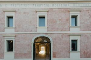 een rood bakstenen gebouw met een boog met de woorden pasadena pitteria bij Alvino Relais Mulino Contemporaneo in Matera