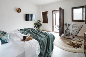 una camera bianca con un letto e una sedia di Winery Hotel 1870 a Firà