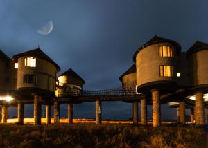 un groupe de maisons avec la lune en arrière-plan dans l'établissement Salt Lick Safari Lodge, à Tsavo