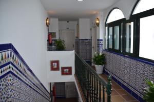 un couloir avec du carrelage bleu et blanc sur un escalier dans l'établissement Hotel Doña Lina, à Séville