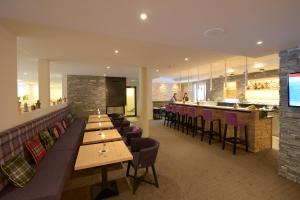 a restaurant with wooden tables and chairs and a bar at Alpenhotel Fleurs de Zermatt in Zermatt