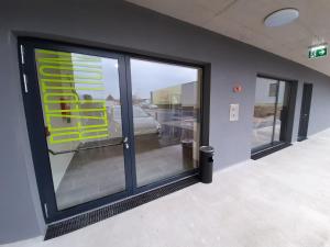 a large glass door in a building with a sign on it at Office Base Bad Vöslau MOTEL in Bad Vöslau