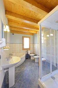 a bathroom with a tub and a toilet and a sink at Hotel L'espoir in Champoluc