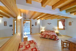 a bedroom with a bed in a room with wooden ceilings at Hotel L'espoir in Champoluc